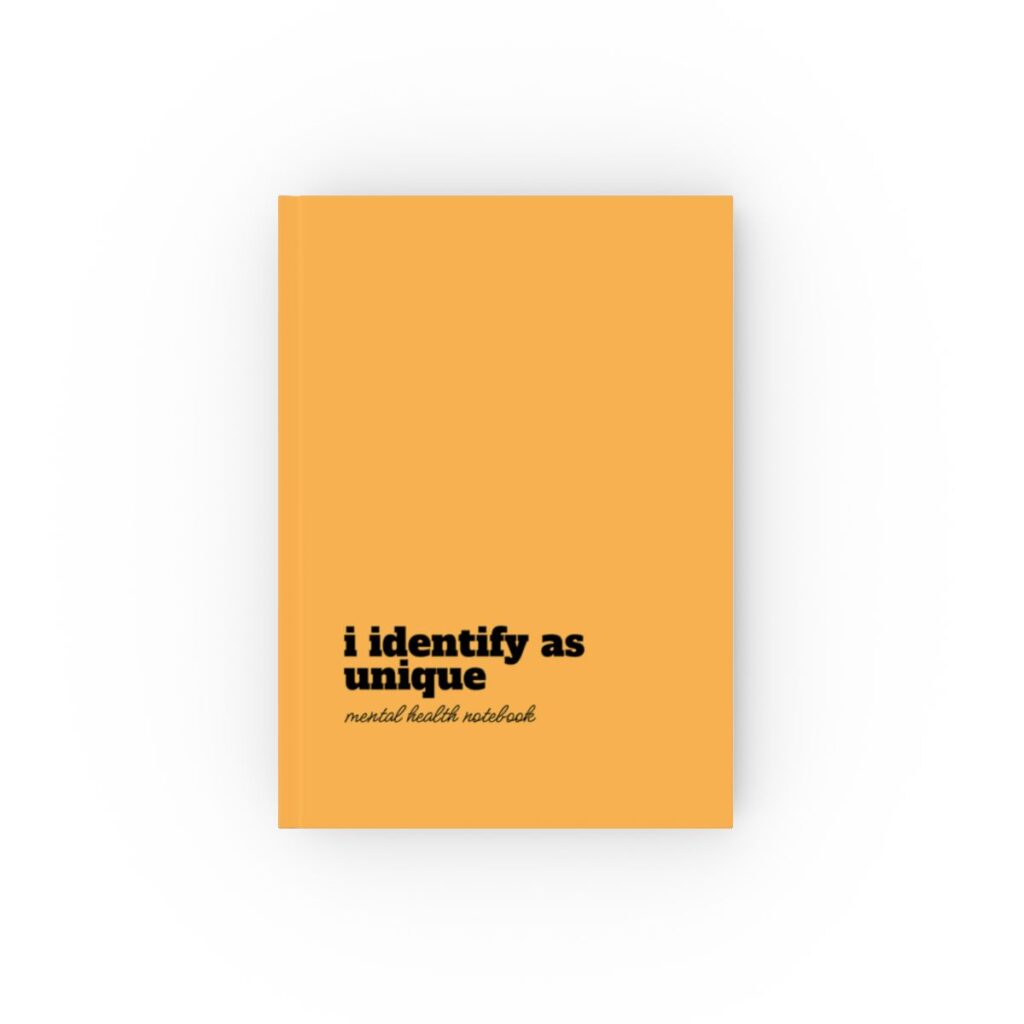 An orange hardcover notebook cover with bold black text reading "i identify as unique." Below, smaller text says "mental health notebook." The tone is empowering by iziiexpressions.com